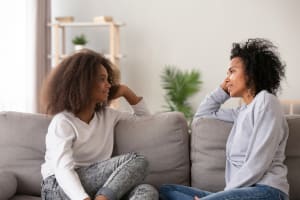 La hija y la madre adolescentes pasan tiempo de calidad juntas en el sofá.