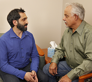 Hombre conversando con un profesional de salud mental.